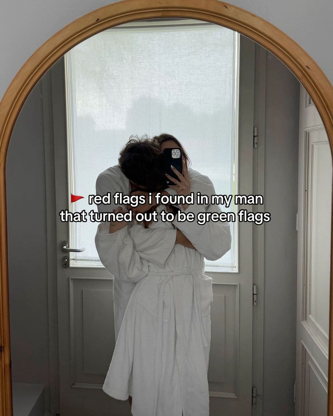 A couple embracing in a mirror under the text red flags I found in my man that turned out to be green flags.