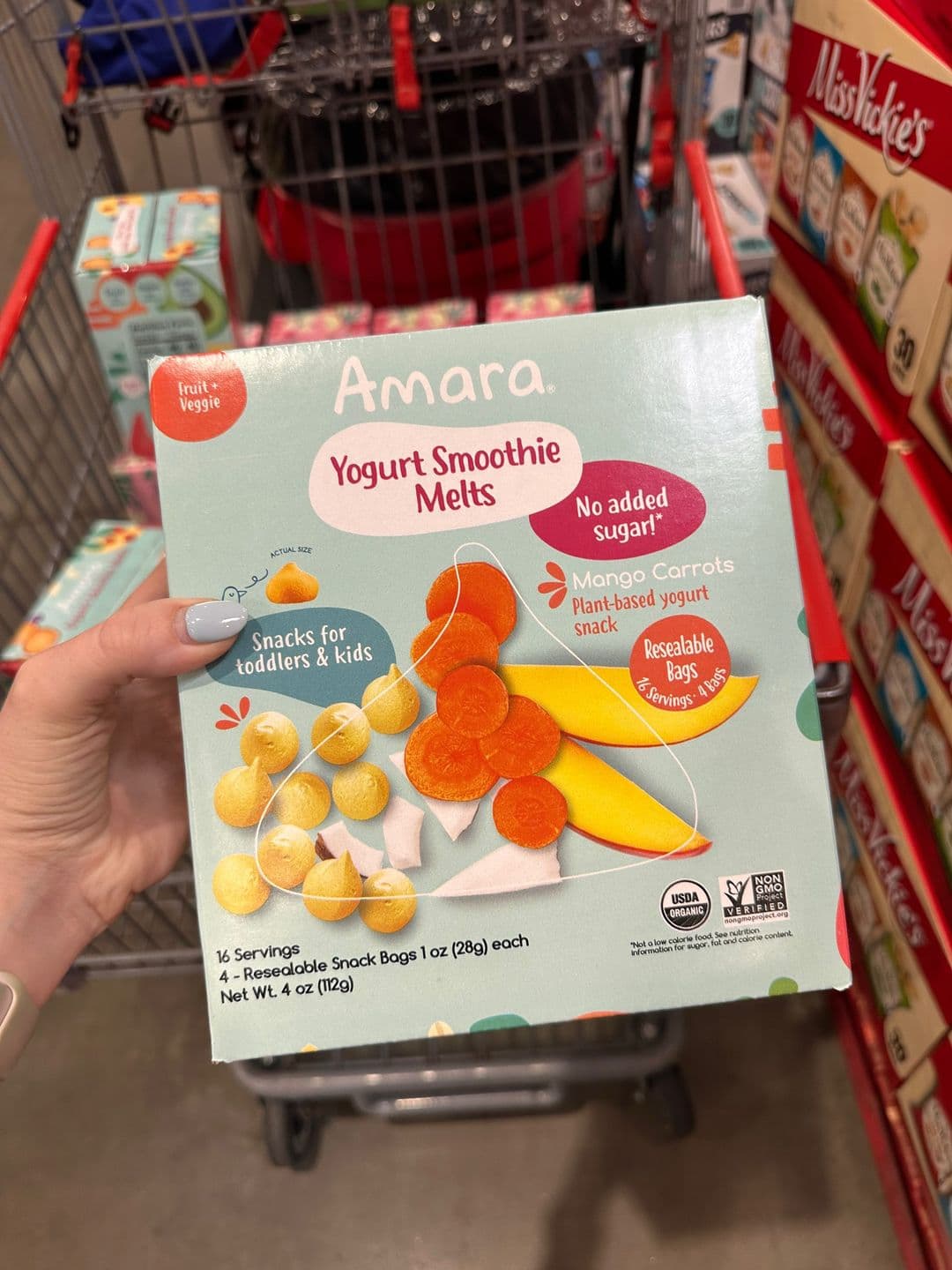 Slide 2, a hand holding a box of Amara Yogurt Smoothie Melts over a Costco cart.