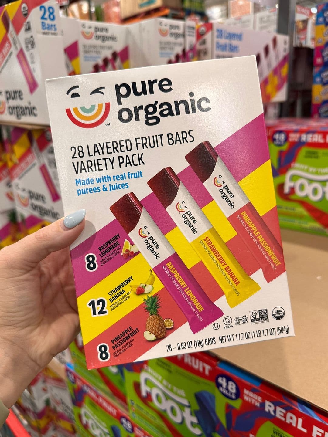 Slide 8, a hand holding a Pure Organic layered fruit bars variety pack.